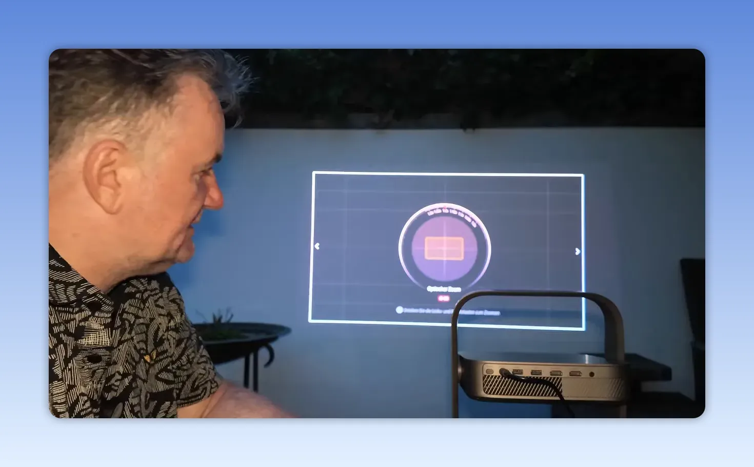 Projektormenü mit Bildzoom und projiziertem Testbild auf einer Wand