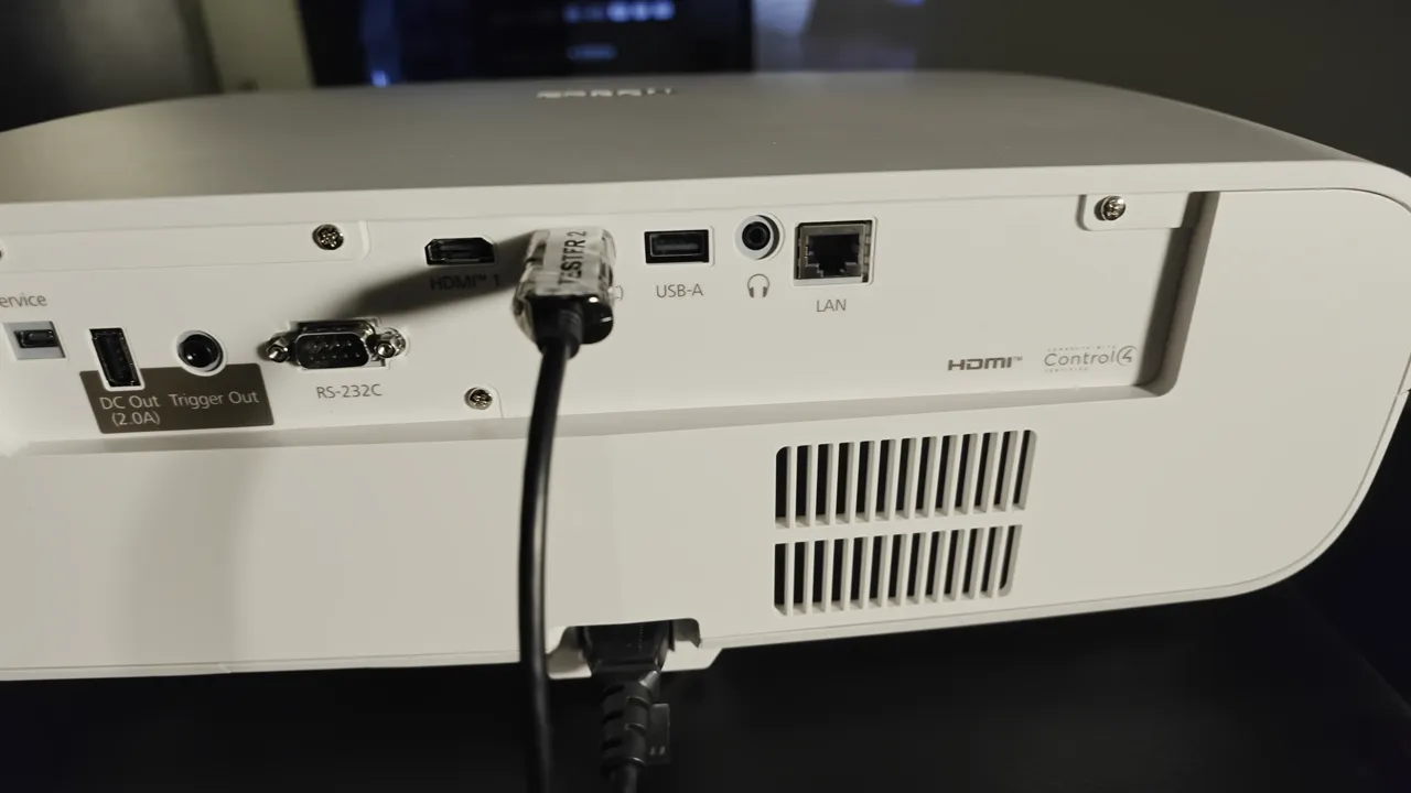Rückseitiges Anschlussfeld des weißen EPSON-Projektors mit HDMI-Kabel, USB, Audioausgang, LAN, RS-232 und Trigger-Ausgang