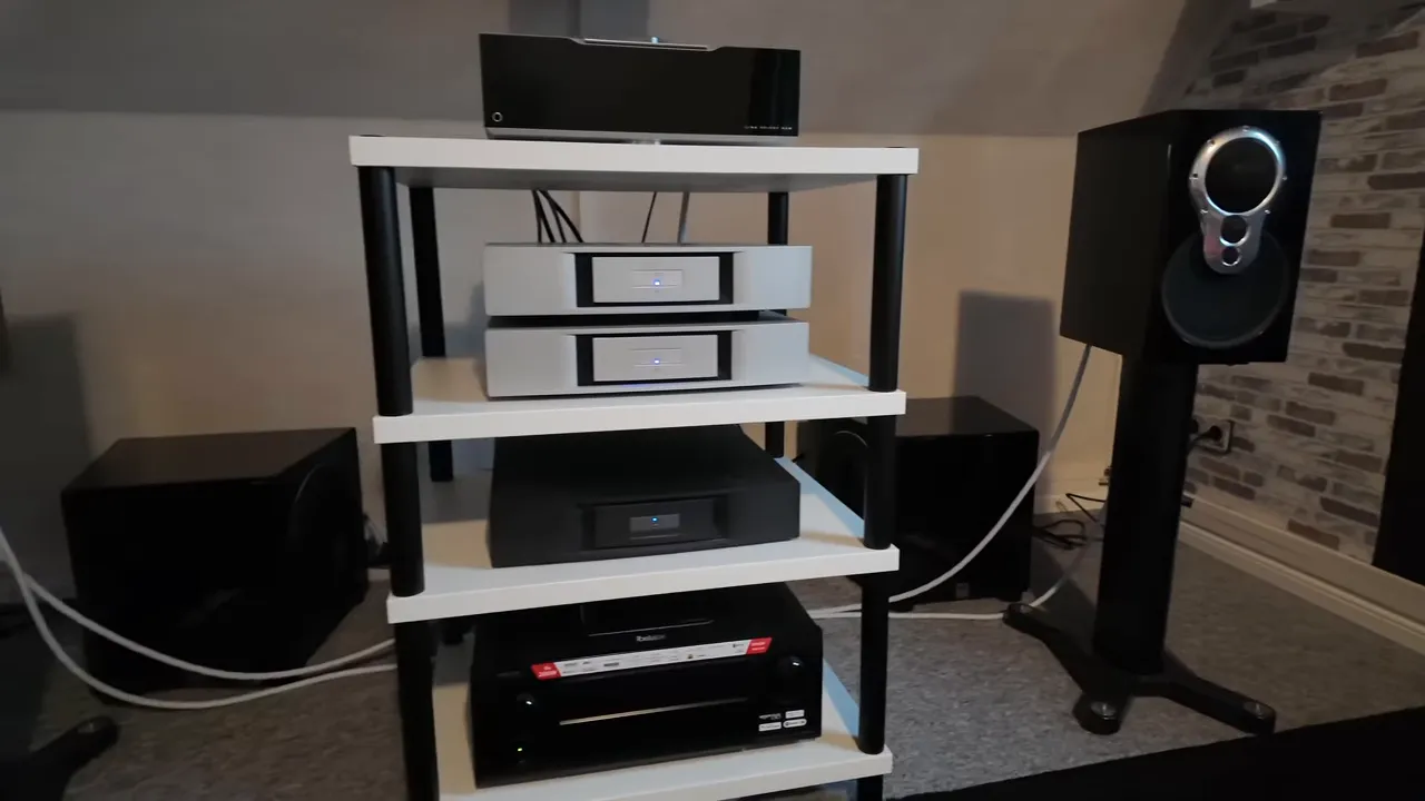 Weißes HiFi-Rack mit separaten Endstufen, Linn-Kompaktlautsprecher auf einem Ständer und vorderen Subwoofern
